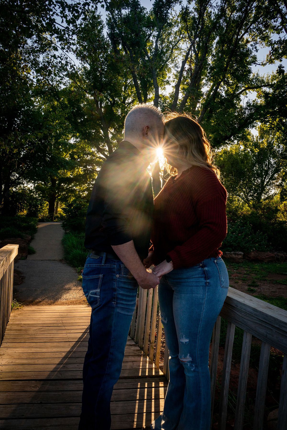 Engaged couple sharing a candid moment during golden hour in Oklahoma.