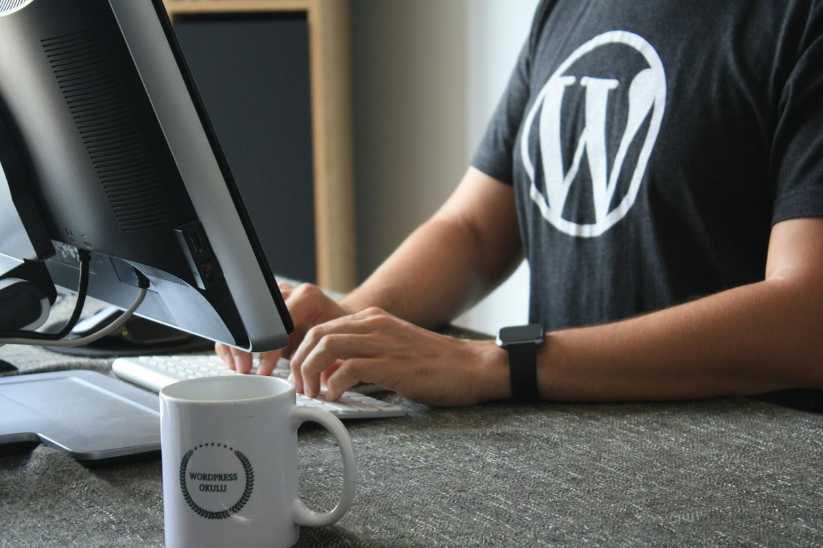 Mann mit WordPress-Logo arbeitet am Computer