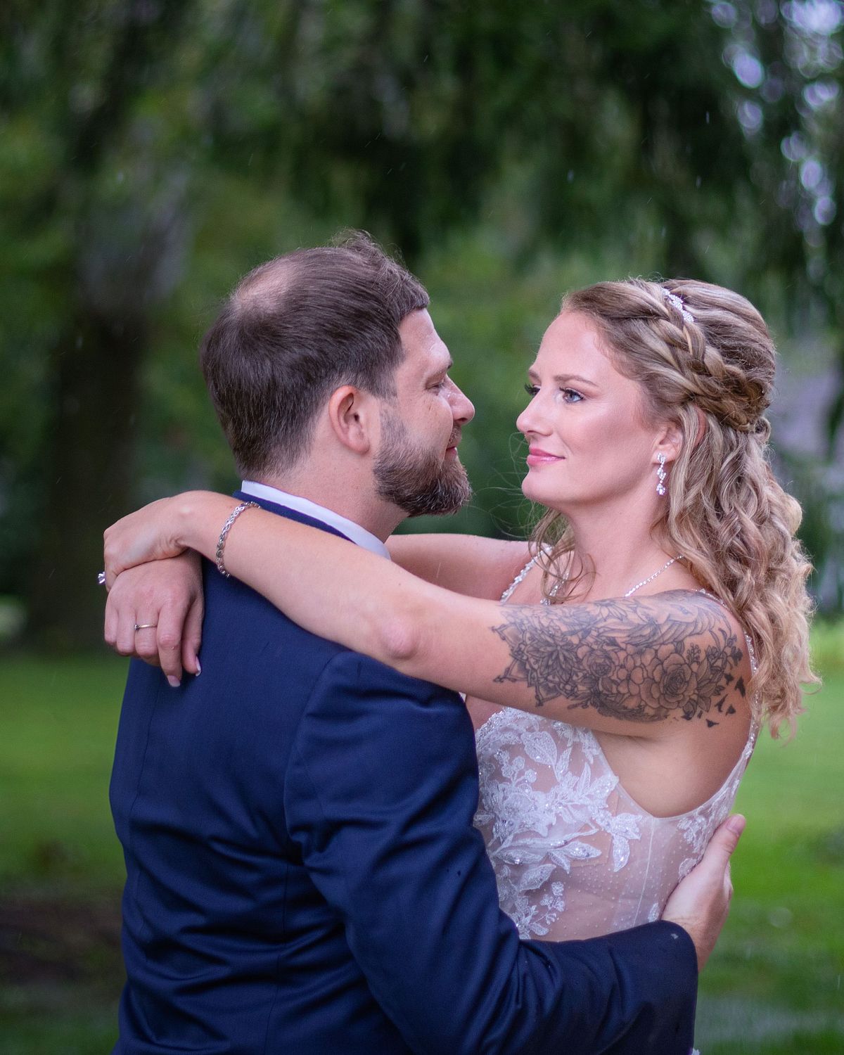 bride and groom closely hugging, the bride is looking into the grooms eyes