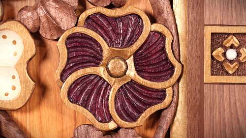 Hand-carved hollyhock flower with purple and gold paint