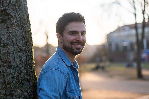 Portrait of Toni Gojanovic leaning against a tree in Monbijou Park in Berlin.