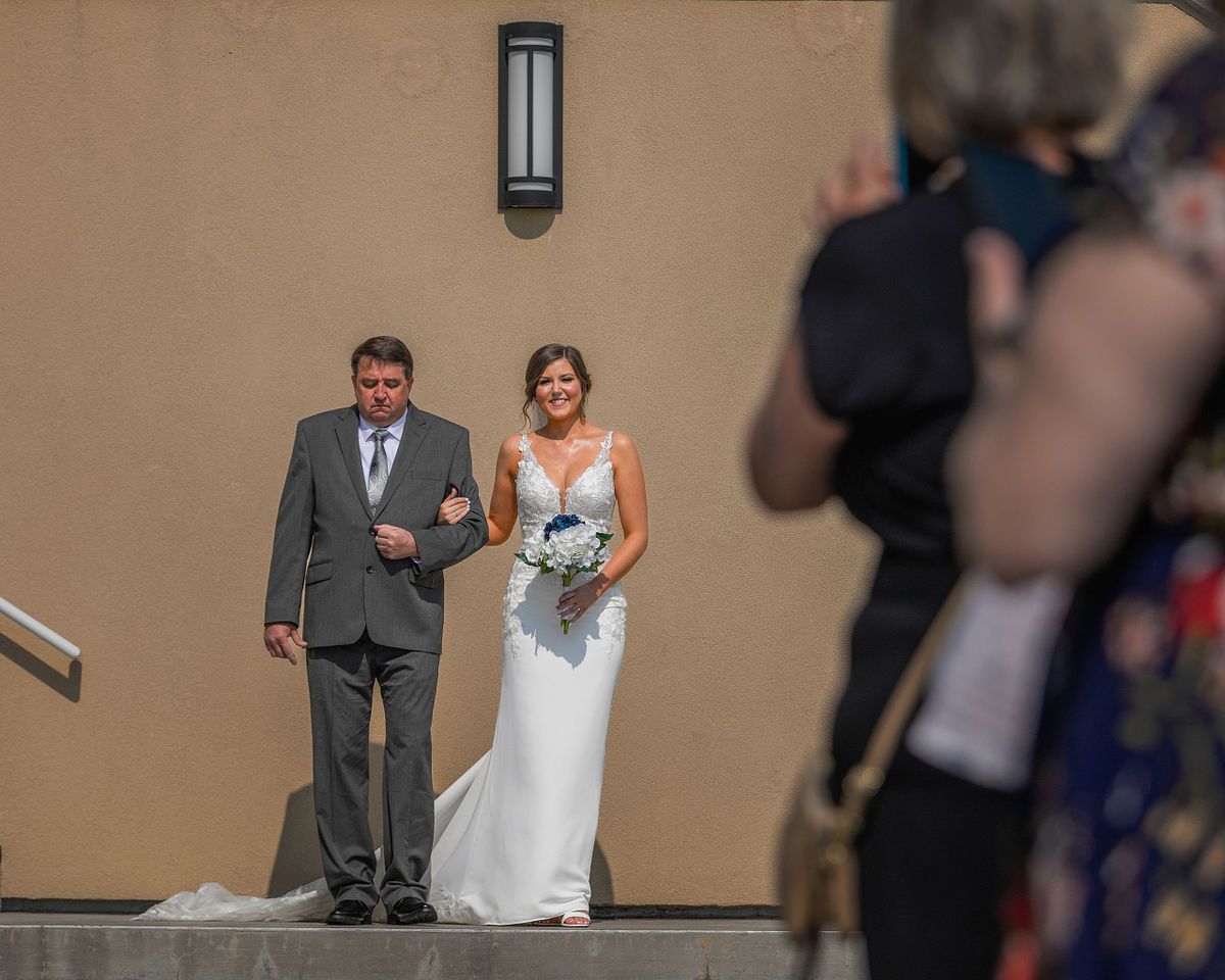 Bride coming down the aisle with her dad at the hyatt in dewey beach
