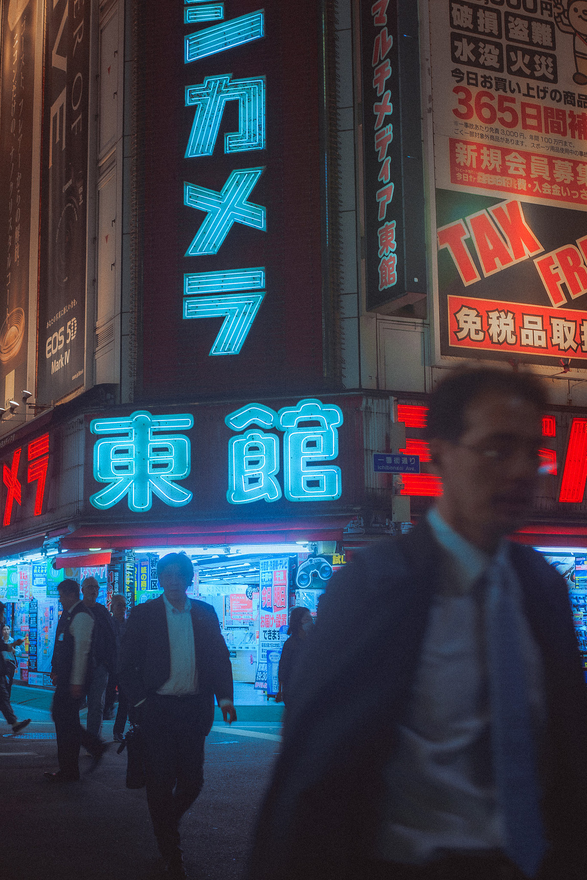 Enseignes au néon de Shinjuku la nuit, salaryman flou au premier plan