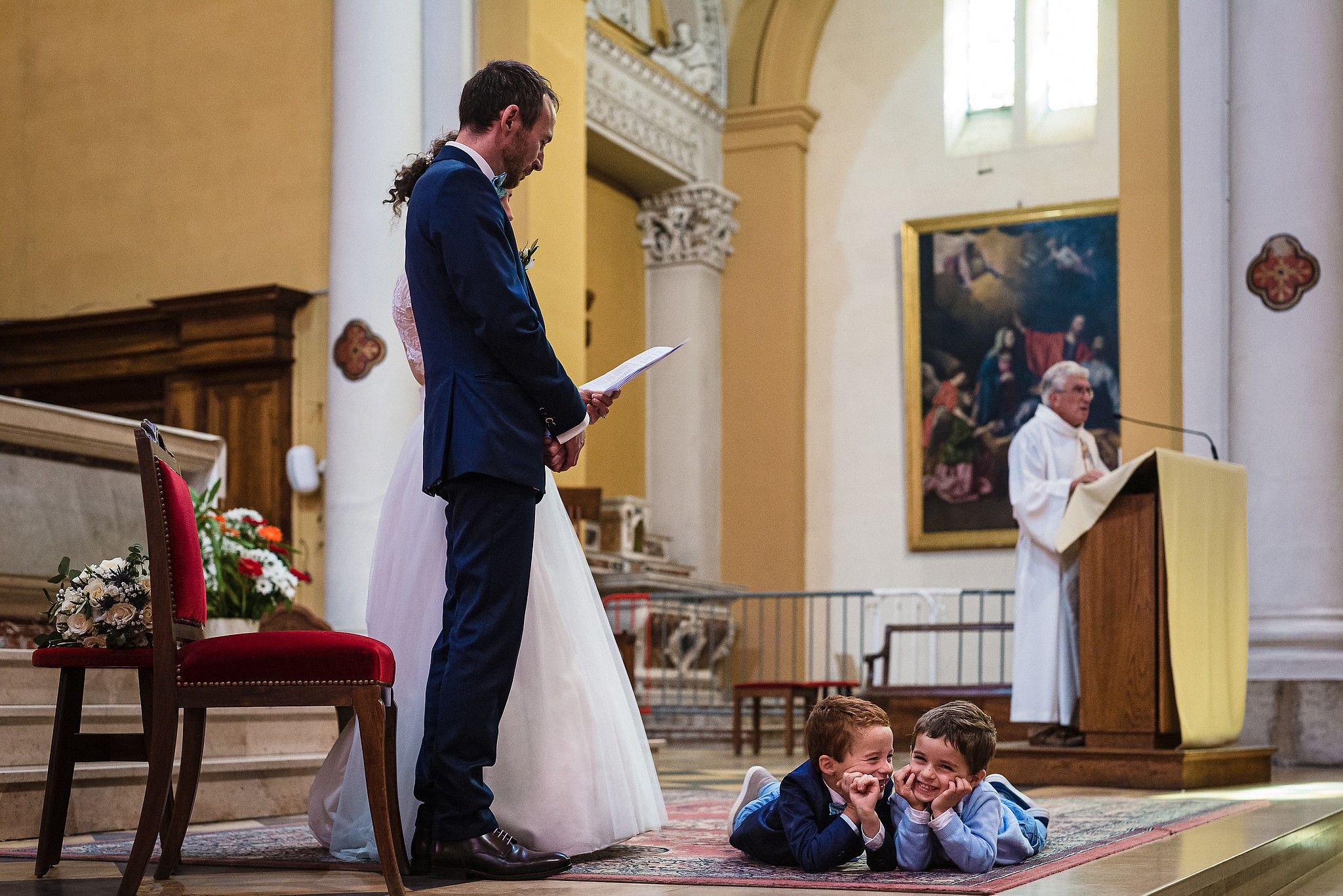 Enfants qui s'amusent par terre pendant la c&eacute;r&eacute;monie religieuse captur&eacute; par S&eacute;bastien CLAVEL photographe de Mariage &agrave; Lyon et Gen&egrave;ve