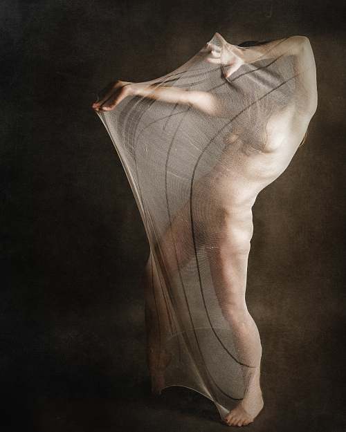Photographie fine art d&rsquo;une femme nue envelopp&eacute;e dans un voile tendu, illustrant la lutte int&eacute;rieure entre protection et ouverture, et la difficult&eacute; de s&rsquo;exposer &eacute;motionnellement &mdash; &oelig;uvre de Pascal Yennis, Namur, Belgique.