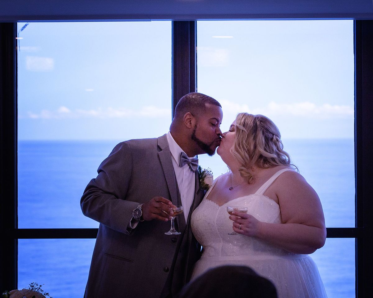 bride and groom kissing during toasts, documented using no flash