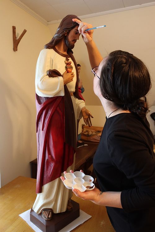Kelly Baker adding final touches to the restored statue's paint