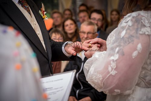 Close-up of the groom placing the wedding ring on the bride’s finger during the ceremony, captured by Weddings By Jermaine.