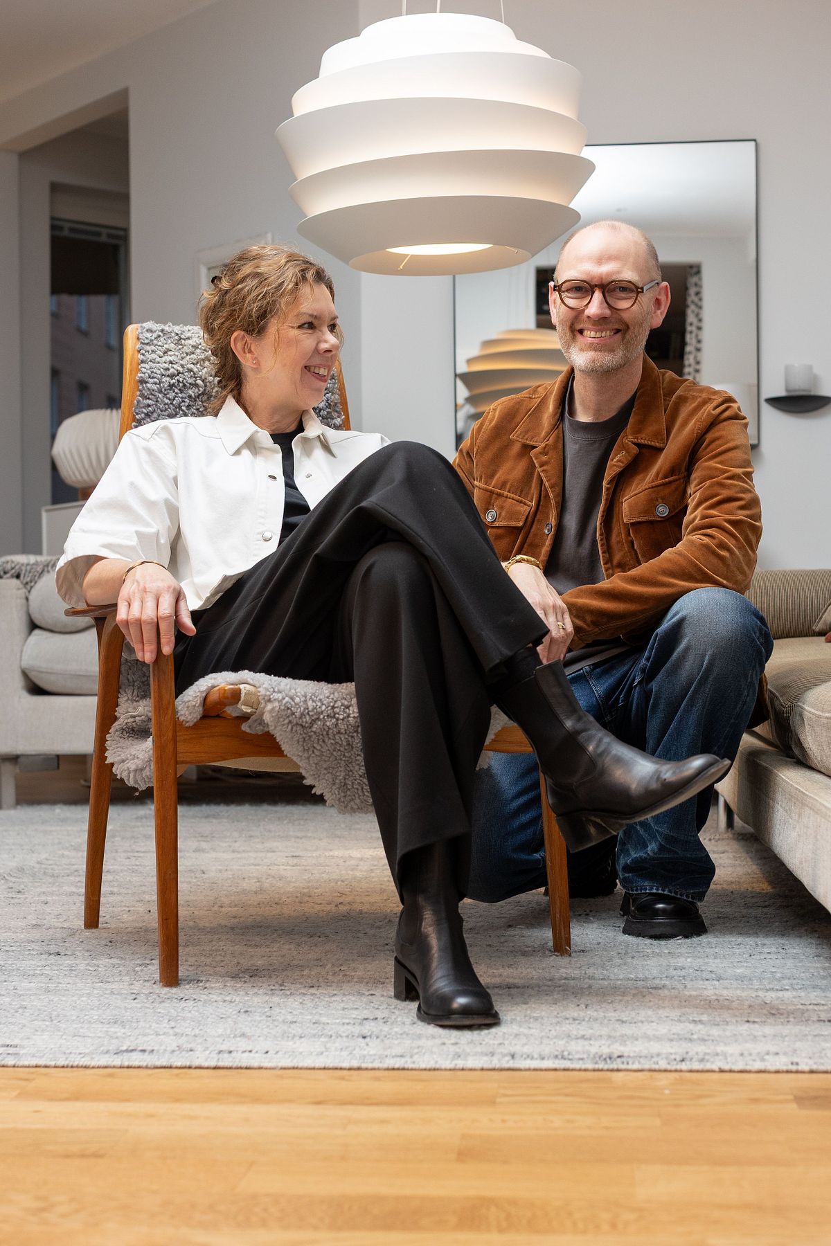 Tv&aring; personer i vardagsrum i skandinavisk milj&ouml;, sittande och avslappnade i ett hemtrevligt sammanhang.