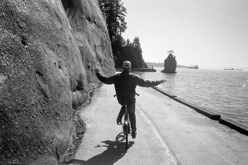 cyclist riding hands free through Stanley Park on 35mm film