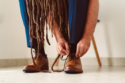 "sposo che si allaccia le scarpe visto dal basso"