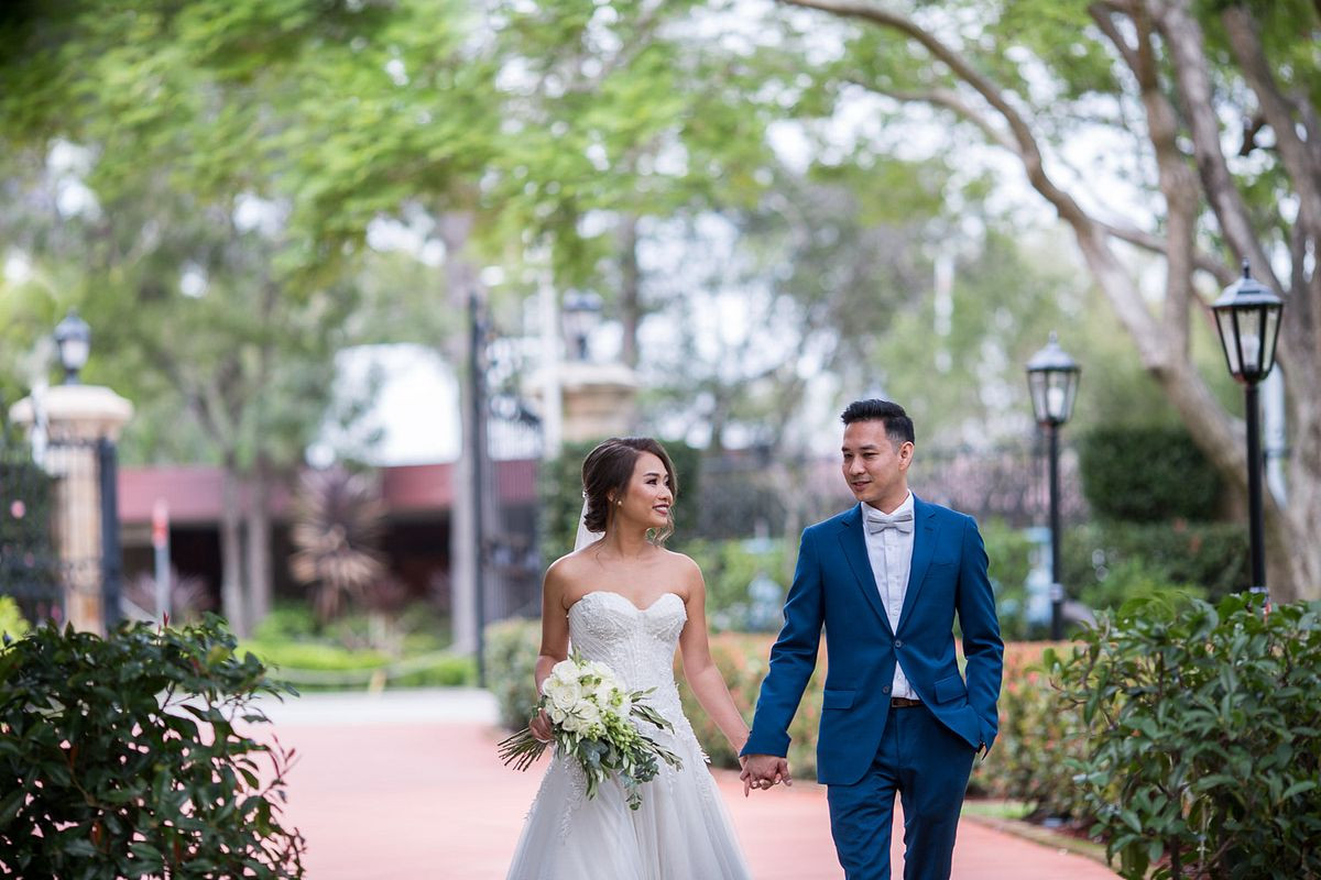 Timeless wedding photo of the bride and groom walking hand in hand at Curzon Hall.