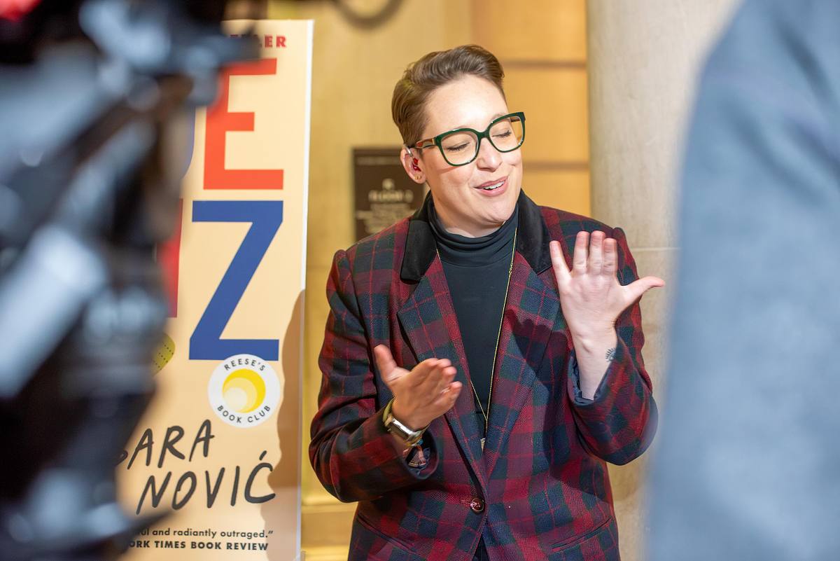 Author Sara Nović speaking in ASL during a press conference at the Free Library of Philadelphia, illustrating leadership communication moments at a public event.