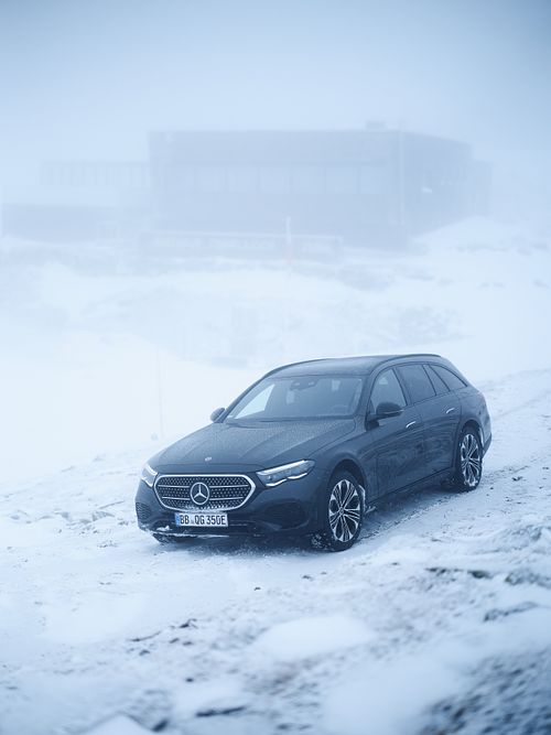 Mercedes Benz E-Klasse T-Model im verschneiten Gebirge.