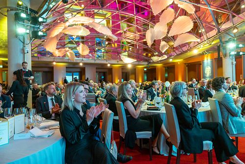 People giving a round of applause during a gala dinner at the Axica Convention Centre in Berlin.