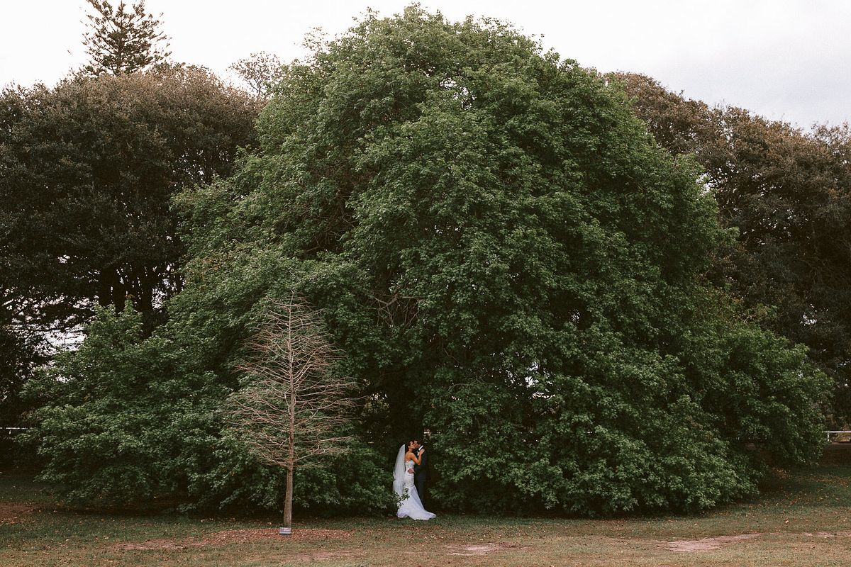 Beautiful wedding photography showcasing the lush of green at One More Shot Pond, Centennial Park.