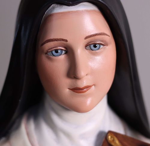 A close-up of the St. Therese statue's face after restoration