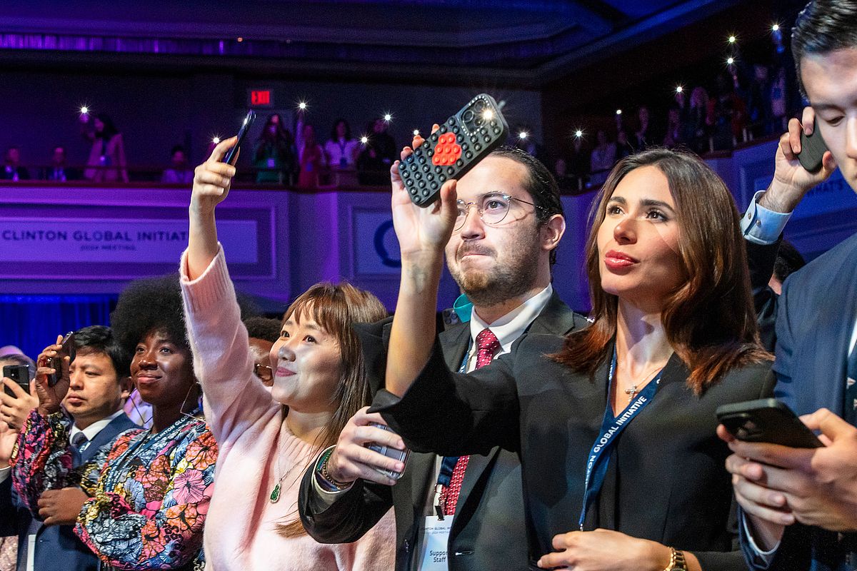 Corporate event photography capturing audience members raising their phones to document a powerful moment during the &ldquo;Future of Funding&rdquo; session at the Clinton Global Initiative 2024 in New York City, highlighting collective engagement and shared impact.