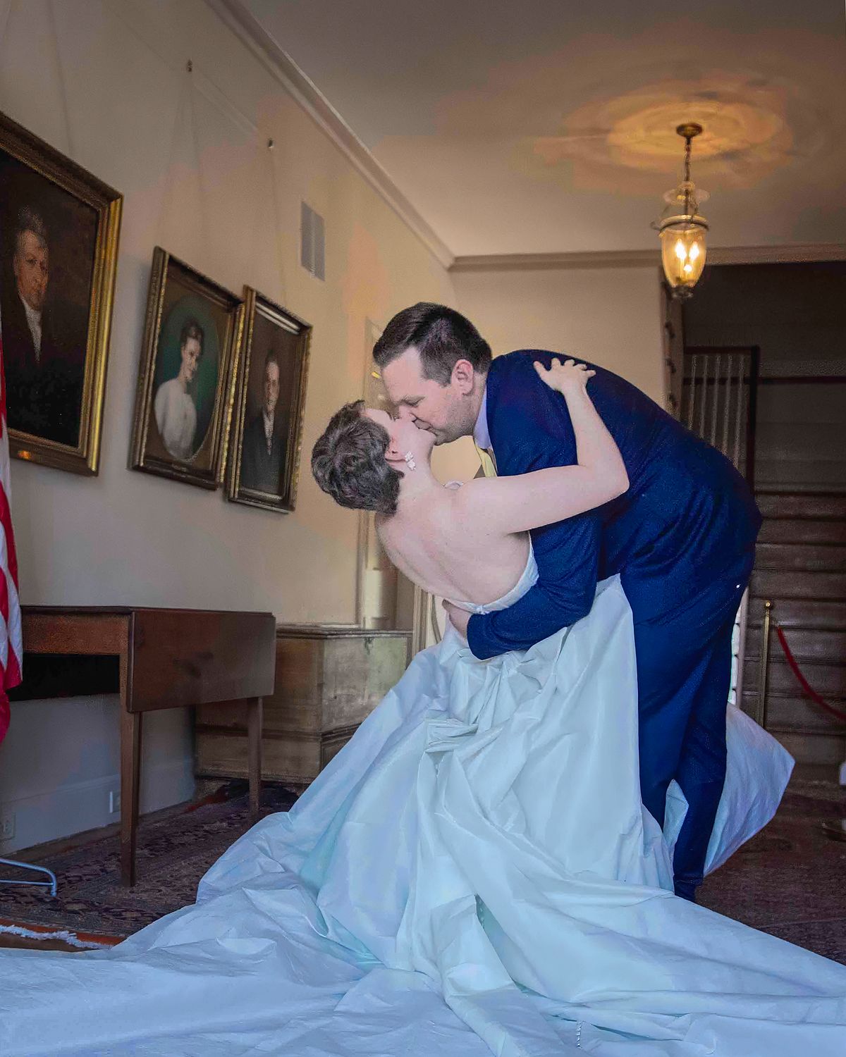 a groom tipping his bride and kissing her, at the mansion on poplar Hill in Salisbury, md