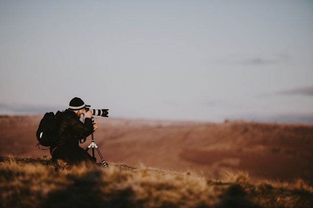 Afbeelding van een fotograaf die een landschapsfoto maakt
