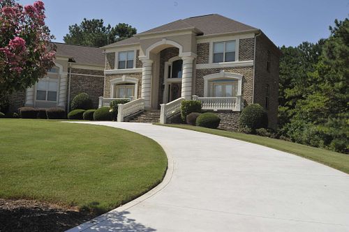 Stately two-story brick home with a charming driveway