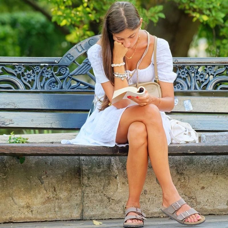 woman on park bench reading a book