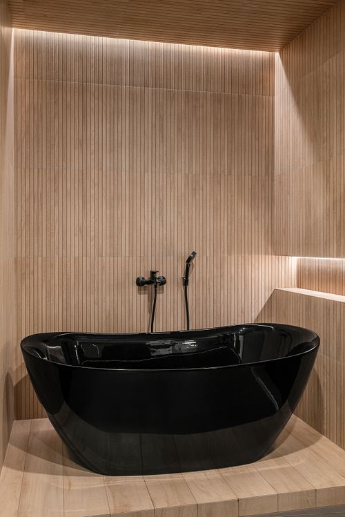 Edgy angle of bathroom with bathtub, soft light, and natural textures – Columna project