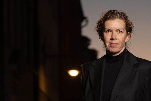 Headshot av kvinna i skymning med mjuk bakgrund och bokeh från stadsljus, professionellt personal branding-porträtt i Stockholm.