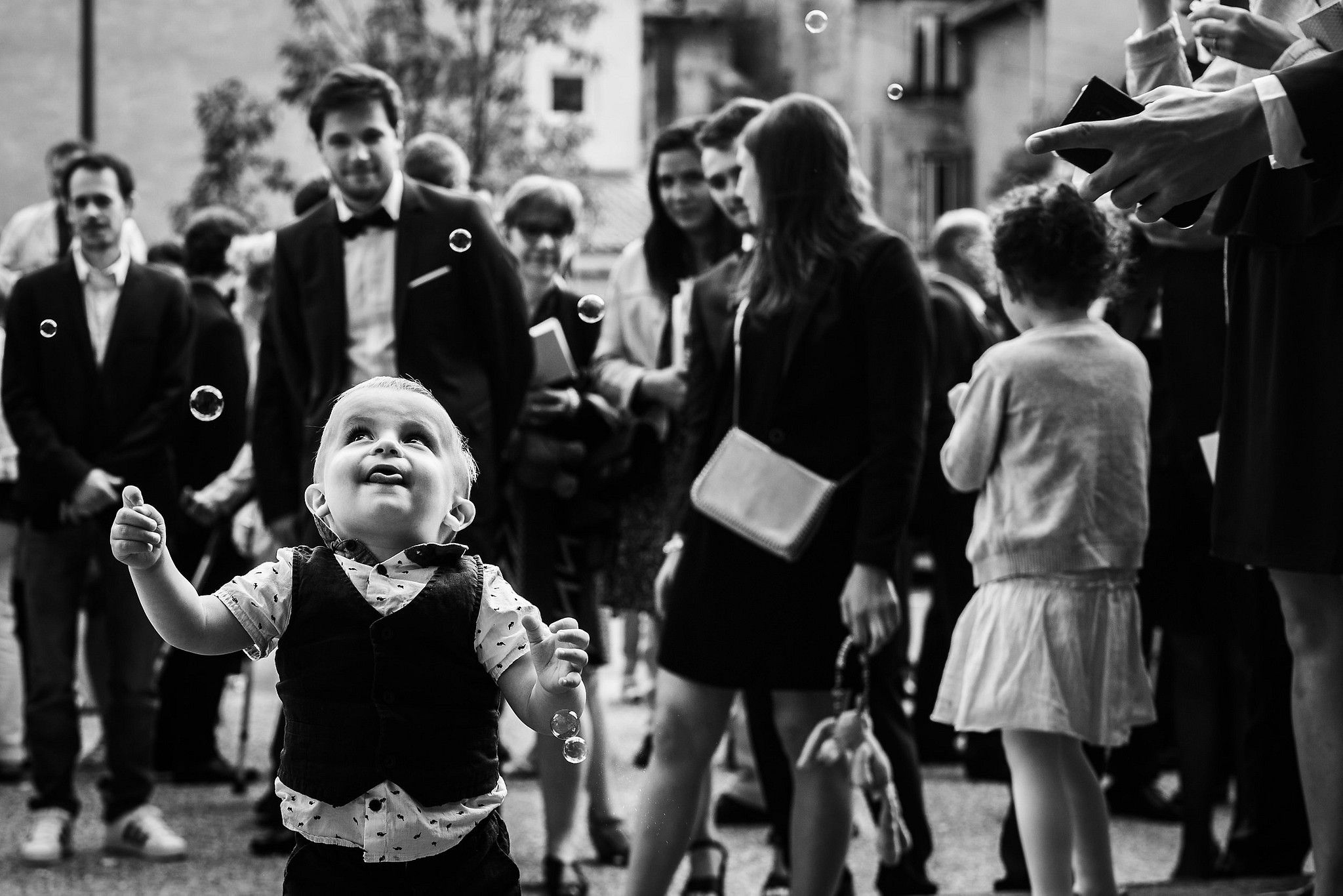 Enfant qui joue aves des bulles &agrave; la sortie de l'&eacute;glise captur&eacute; par S&eacute;bastien CLAVEL photographe de Mariage &agrave; Lyon et Gen&egrave;ve