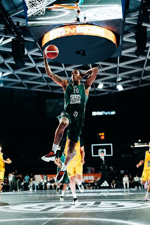 Basketballspieler beim spektakulären Dunk in einer vollen Arena