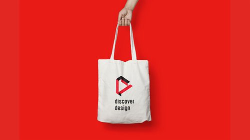 Mockup of a white tote bag featuring the primary full-colour Discover Design logo centred on the front.