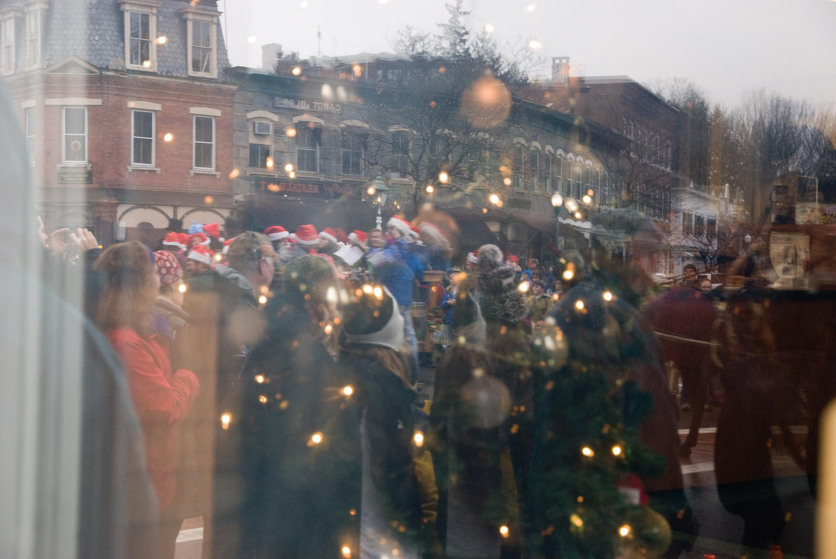 Wassail Weekend Christmas parade and parade watchers reflected in window