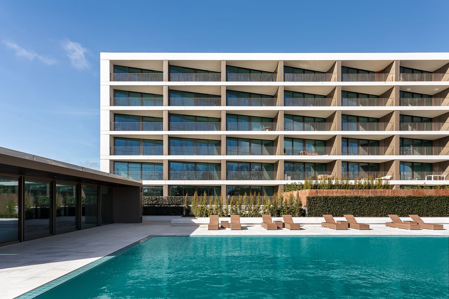 Fachada moderna do edifício Legacy Residences em Cascais, com piscina e áreas exteriores, fotografada por Pedro Brás Photography — fotografia profissional de arquitetura e imobiliário de luxo em Portugal.