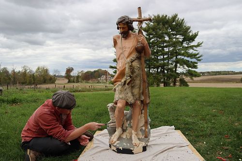 Wes Baker scraping loose paint from St. John the Baptist statue