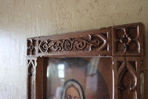 detail of the Marian monogram on the upper carving on walnut picture frame