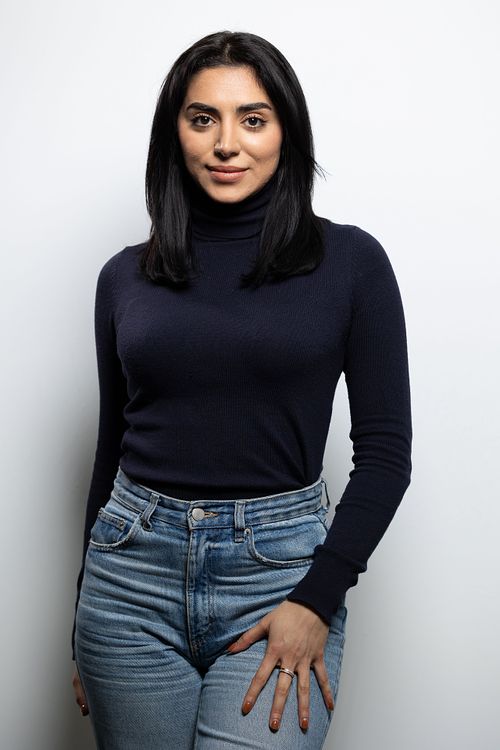 Halvfigur i studio av skådespelare med direkt närvaro, neutral bakgrund och kontrollerat ljus.