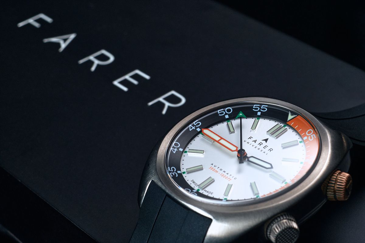 Mechanical dive watch sitting on a branded box.