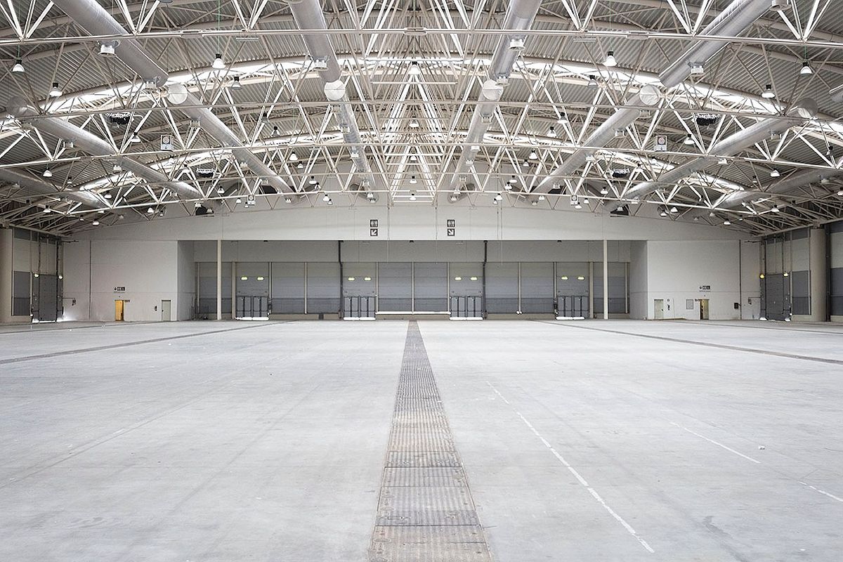 Large industrial interior with steel structure and natural light, corporate space