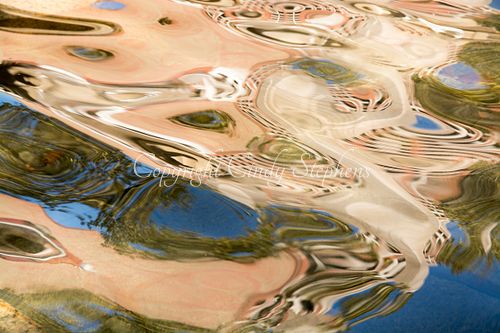 Abstract photograph featuring fluid, swirling patterns of azure, peach, and green that create a mesmerizing rhythm, inviting contemplation and evoking the beauty of peacock feathers