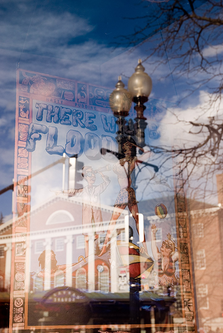 Reflection of Hasty Pudding theatrical poster with man using binoculars