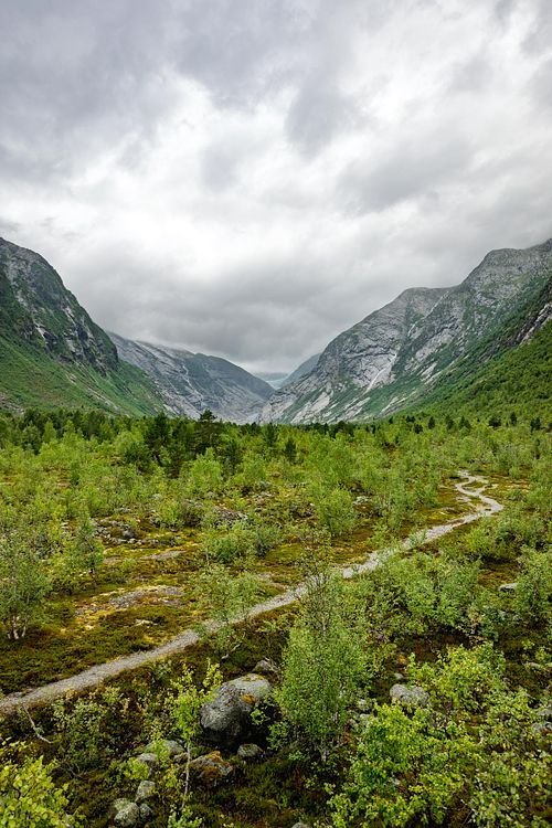 Versants végétalisés sous un ciel à trouées.