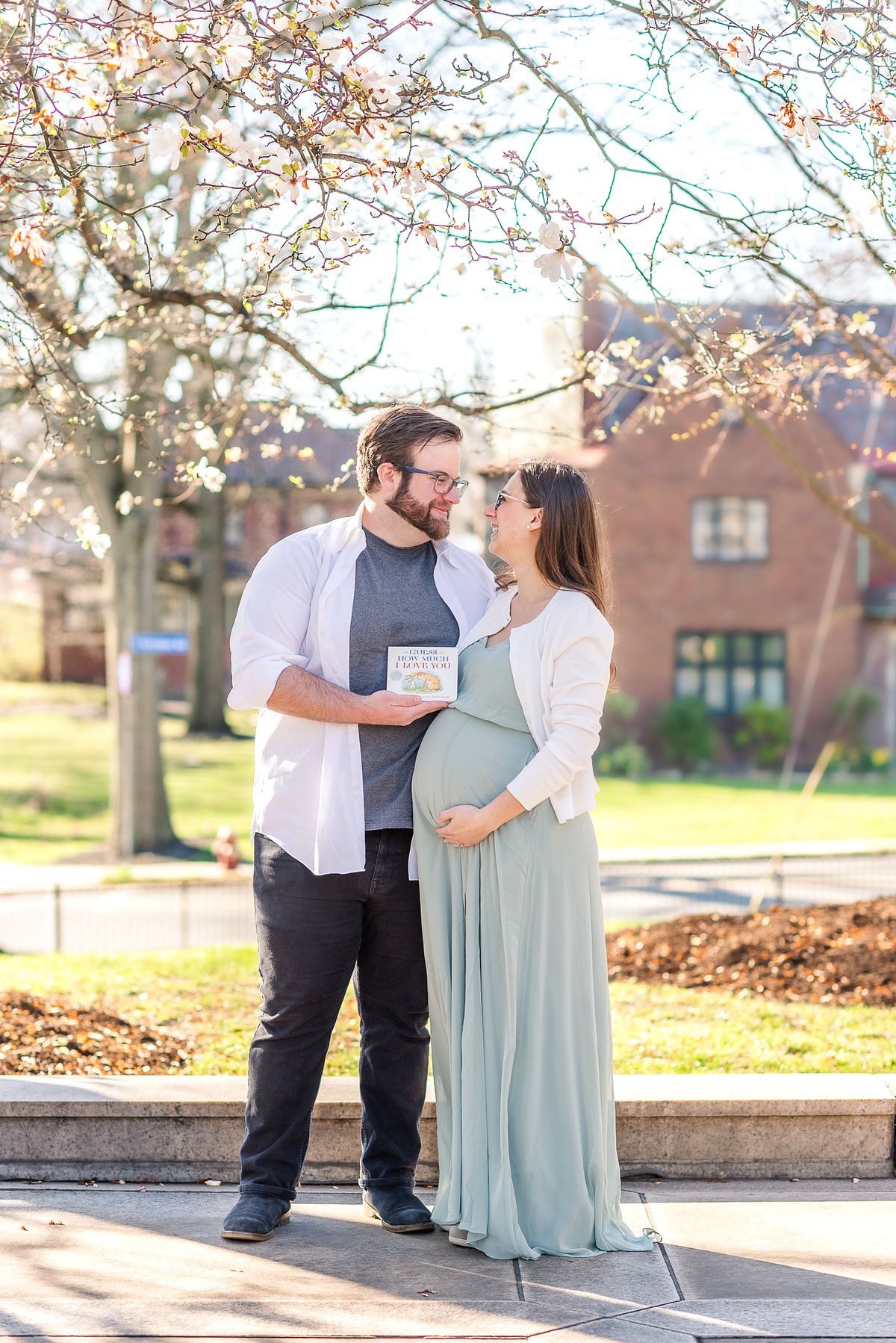 Husband and expectant wife holding Guess How Much I Love You book at The Frick