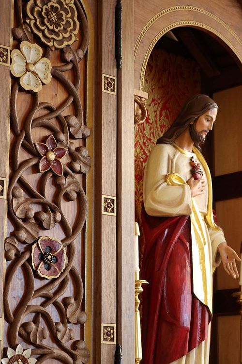 Sacred Heart of Jesus statue in its custom shrine showing one of the door panels with its vines and flowers