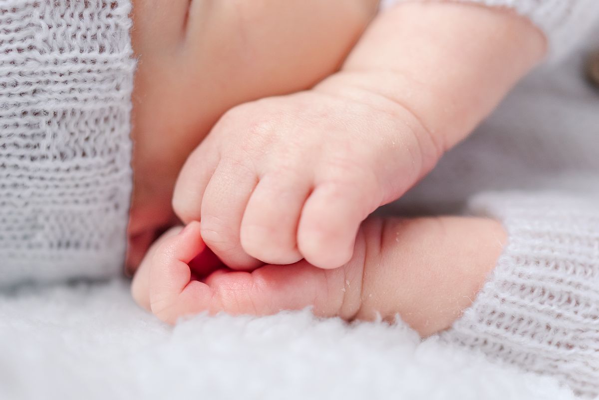 Sleeping baby boy with hands next to his face