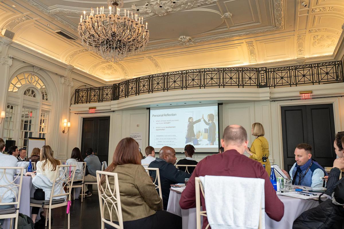Corporate conference session at The Bellevue Hotel in Philadelphia with speaker presenting to attendees in a large ballroom setting.