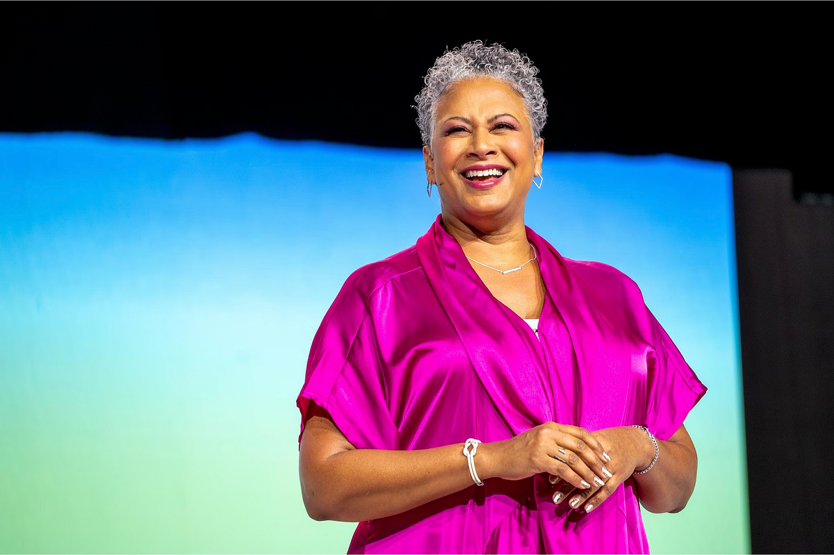 Keynote speaker presenting on stage at the Grace Hopper Celebration 2024, photographed in front of a large audience of women in technology, capturing leadership presence, inspiration, and representation in corporate event environments.