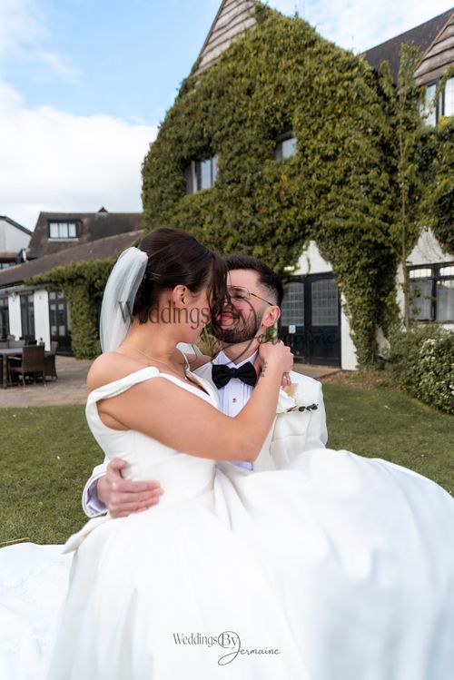 Wedding by Jermaine – groom lifting his bride in a joyful wedding moment at Sketchley Grange Hotel