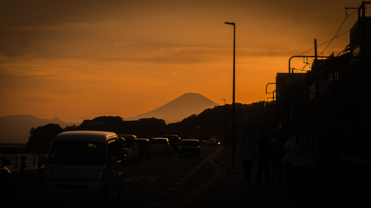 Route côtière de Kamakura au coucher du soleil, le mont Fuji en silhouette au fond