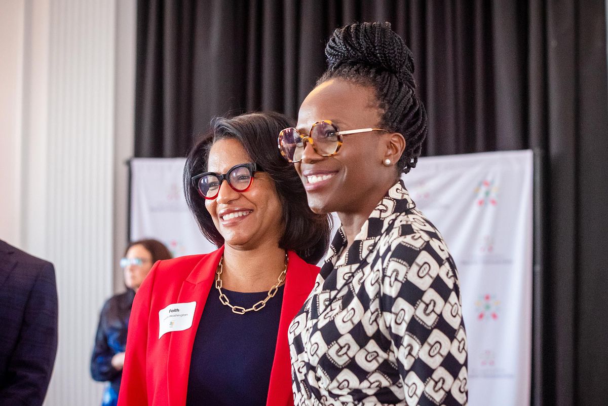 Corporate event photography capturing a healthcare and community leader smiling and engaging in conversation with an attendee during a networking event in Philadelphia, emphasizing authentic connection, representation, and professional presence.