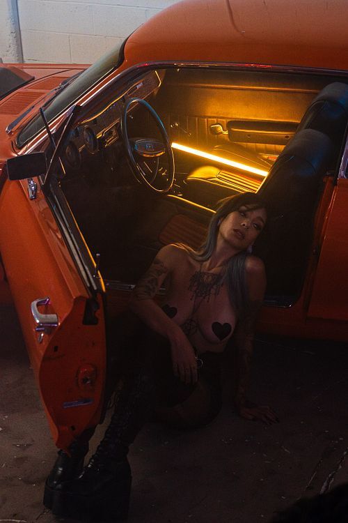 Seated studio lifestyle portrait of Fawn Winters topless in a Mercury Cougar — captured by David Andrade, Las Vegas